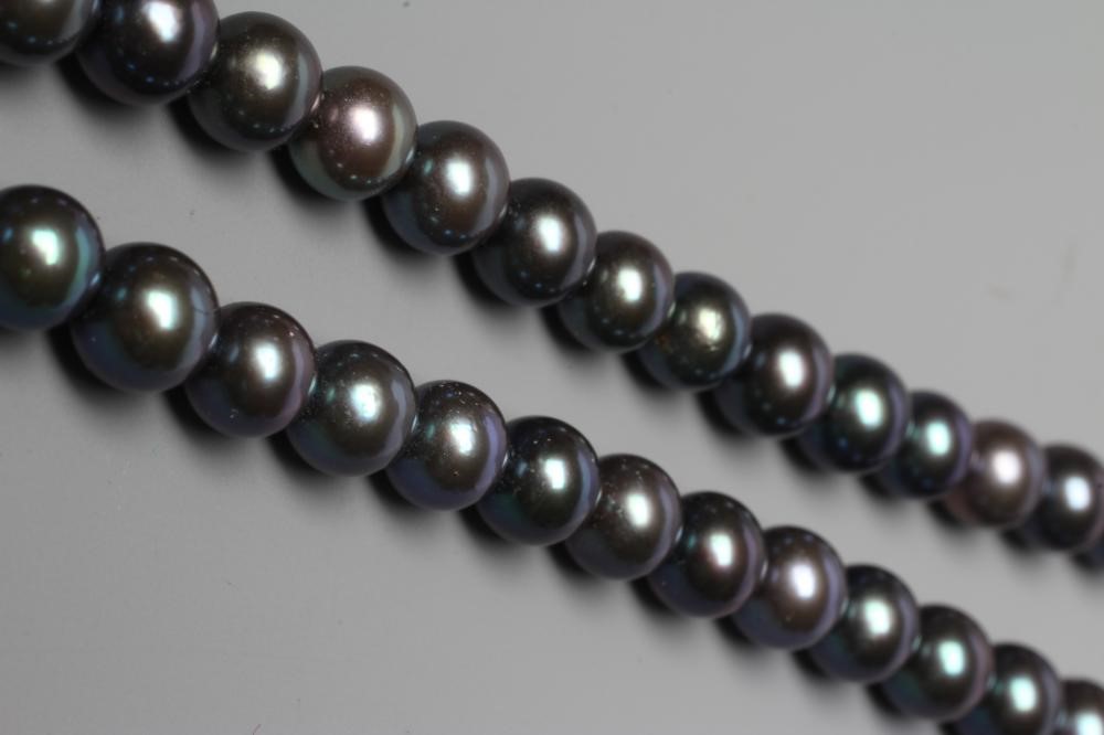 A SINGLE STRING OF BLACK CULTURED PEARLS, the circular clasp stamped 750 and point set with seven Image