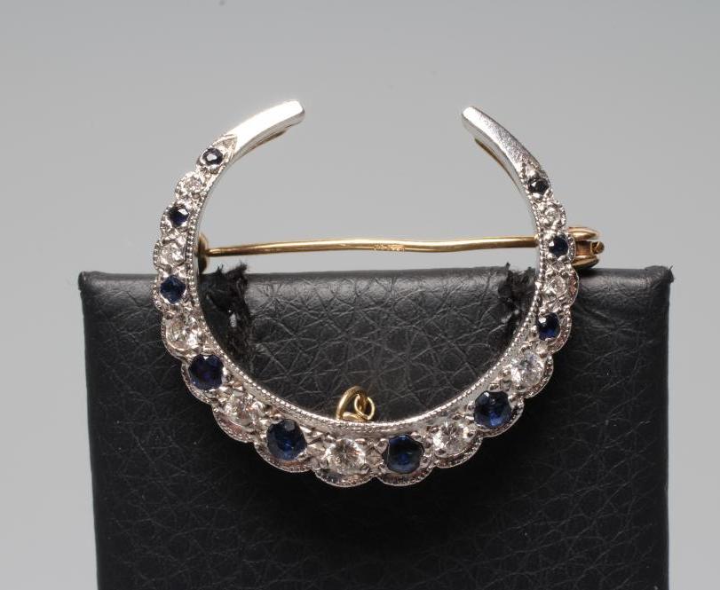 A SAPPHIRE AND DIAMOND CRESCENT BROOCH, the ten graduated small sapphires and nine brilliant cut Image