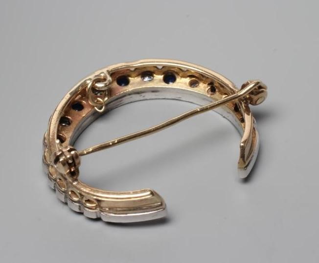 A SAPPHIRE AND DIAMOND CRESCENT BROOCH, the ten graduated small sapphires and nine brilliant cut Image