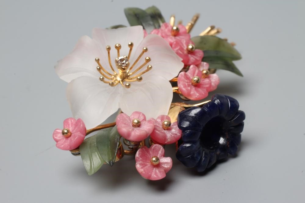 A SPRAY BROOCH with crystal and nephrite flowers and leaves and a diamond stigma, all set to a plain Image