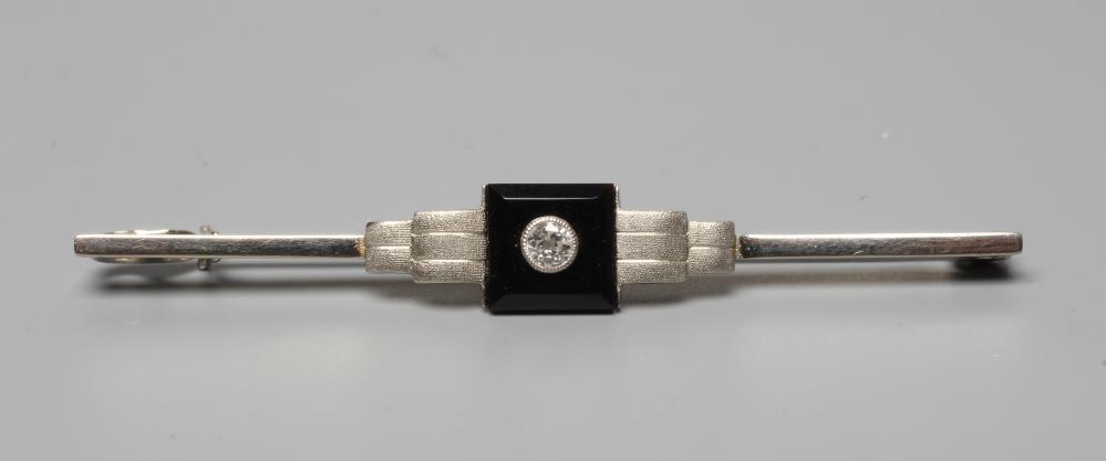 AN ART DECO BAR BROOCH, the central black onyx square panel collet set with a small diamond between Image