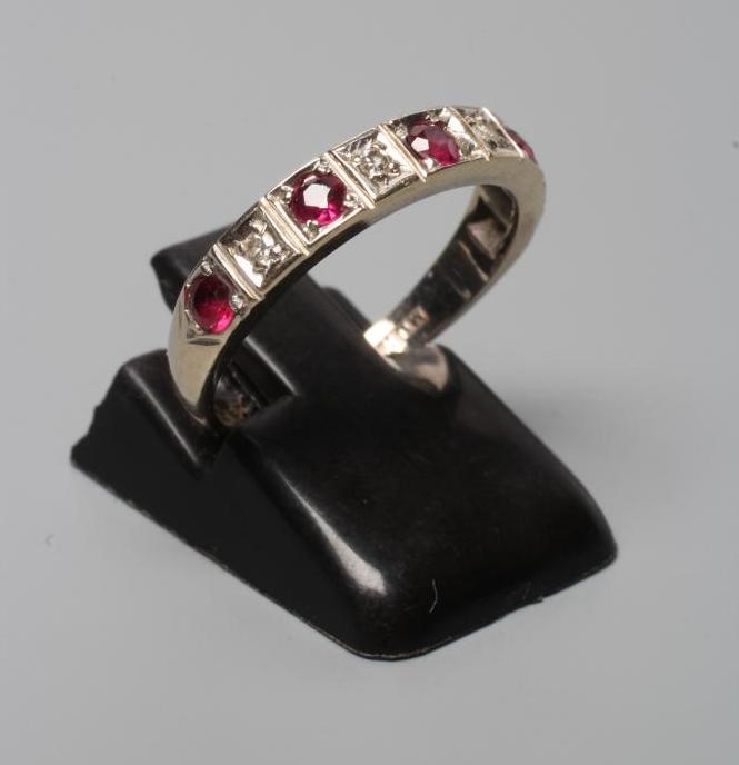 A RUBY AND DIAMOND HALF HOOP RING, the five rubies and four small diamonds point set to a plain Image