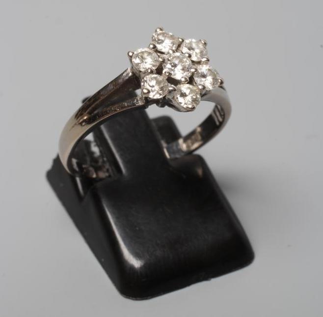A DIAMOND CLUSTER RING, the seven brilliant cut stones in an open setting to a plain 18ct white gold Image