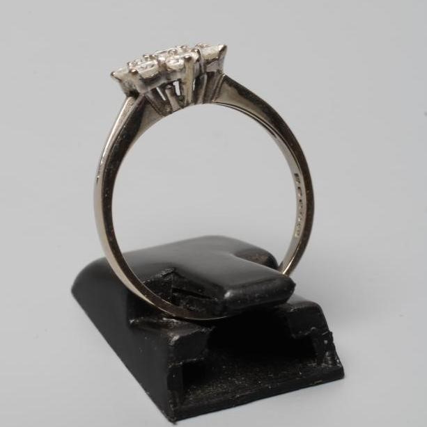 A DIAMOND CLUSTER RING, the seven brilliant cut stones in an open setting to a plain 18ct white gold Image