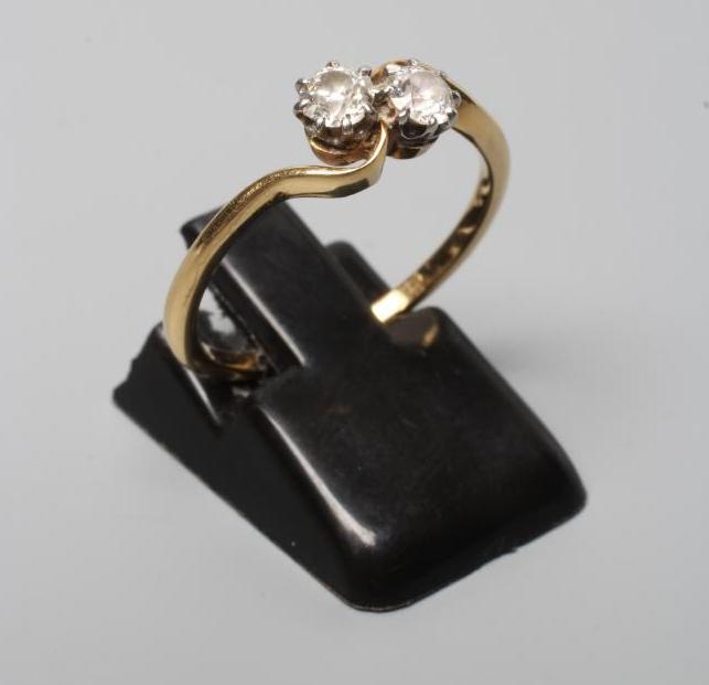 A TWO STONE DIAMOND CROSSOVER RING, the brilliant cut stones each of approximately 0.25 cts, claw Image