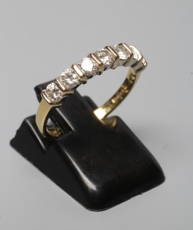 A SEVEN STONE DIAMOND HALF HOOP ETERNITY RING, the round brilliant cut stones line set to a plain Image