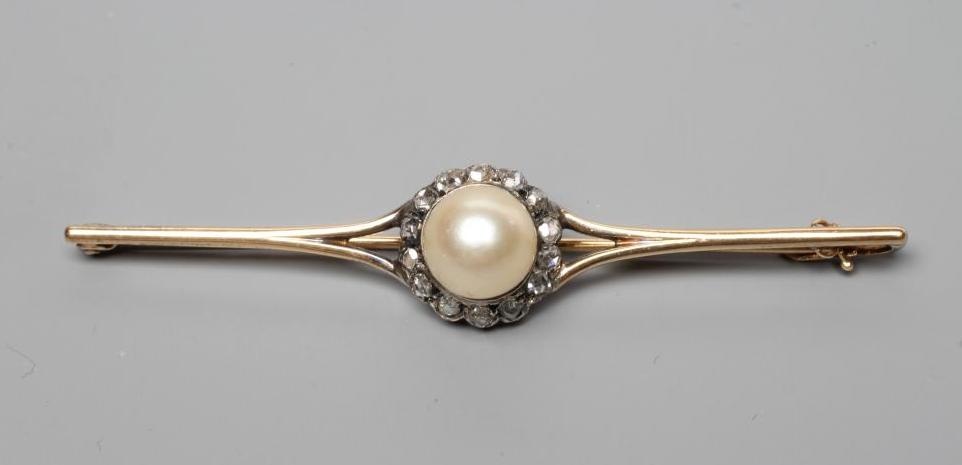 A LATE VICTORIAN PEARL AND DIAMOND BROOCH, the peg set pearl within a border of fourteen rose cut Image