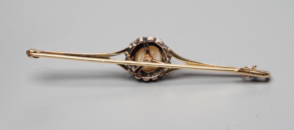 A LATE VICTORIAN PEARL AND DIAMOND BROOCH, the peg set pearl within a border of fourteen rose cut Image