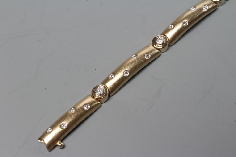 A DIAMOND BRACELET, the nine matt solid rounded oblong links each gypsy set with four small stones Image