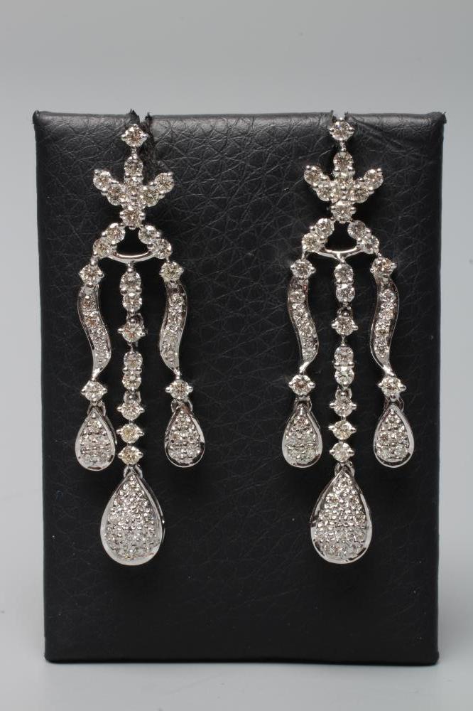 A PAIR OF DIAMOND DROP EARRINGS, each with three husk drops pendant from a stylised flower stud to Image