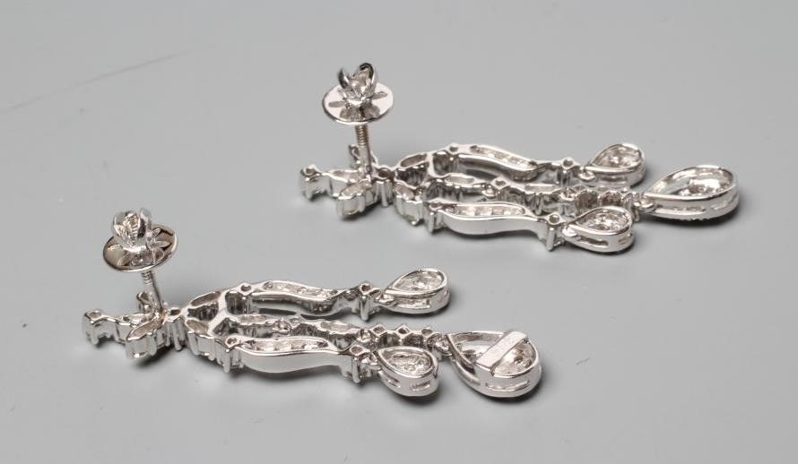 A PAIR OF DIAMOND DROP EARRINGS, each with three husk drops pendant from a stylised flower stud to Image