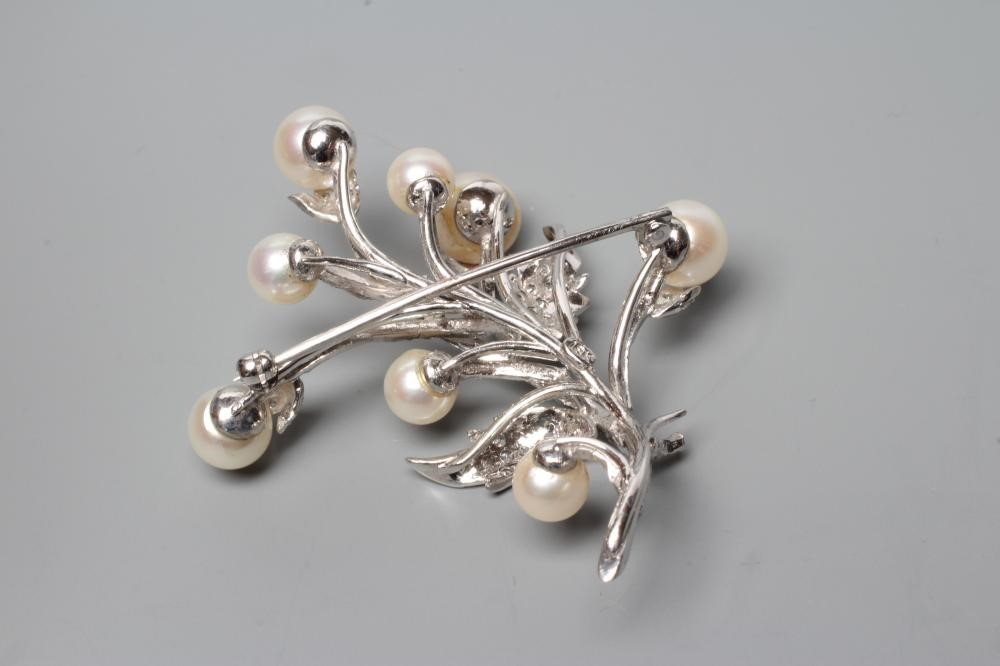A PEARL AND DIAMOND SPRAY BROOCH, the nine cultured pearls peg set to a white frame stamped 18K, the Image
