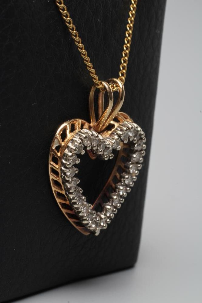 A DIAMOND OPEN HEART PENDANT, the twenty five small round brilliants point set to an unmarked frame Image