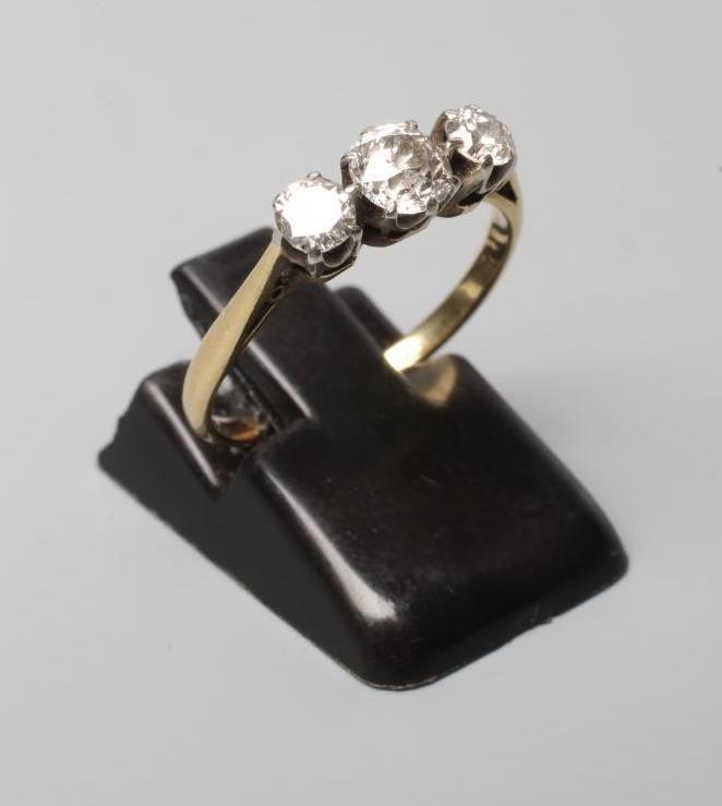 A THREE STONE DIAMOND RING, the central brilliant cut stone of approximately 0.25cts flanked by two Image