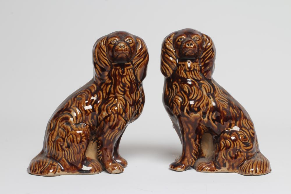 A PAIR OF EARLY VICTORIAN TREACLE GLAZED HEAVY STONEWARE SPANIELS modelled with a free standing fore Image