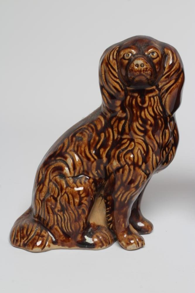 A PAIR OF EARLY VICTORIAN TREACLE GLAZED HEAVY STONEWARE SPANIELS modelled with a free standing fore Image