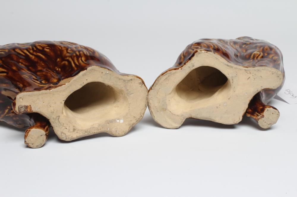 A PAIR OF EARLY VICTORIAN TREACLE GLAZED HEAVY STONEWARE SPANIELS modelled with a free standing fore Image
