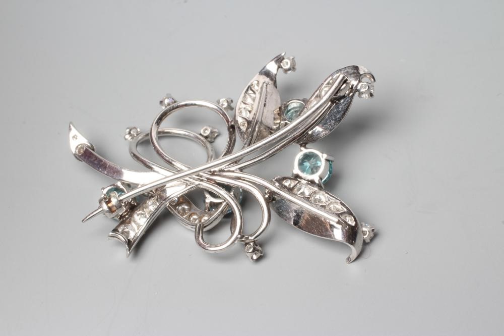 A BLUE ZIRCON AND DIAMOND SPRAY BROOCH of open wirework form claw set with four facet cut zircons Image