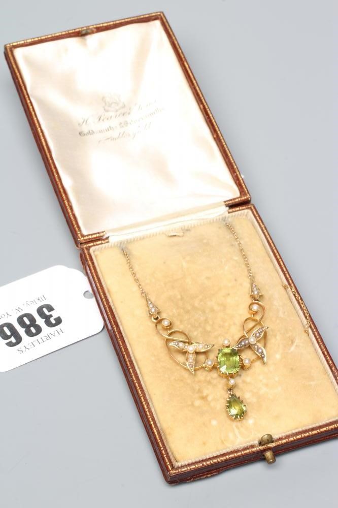 AN EDWARDIAN PERIDOT AND SEED PEARL PENDANT of typical scroll wirework form claw set with two Image