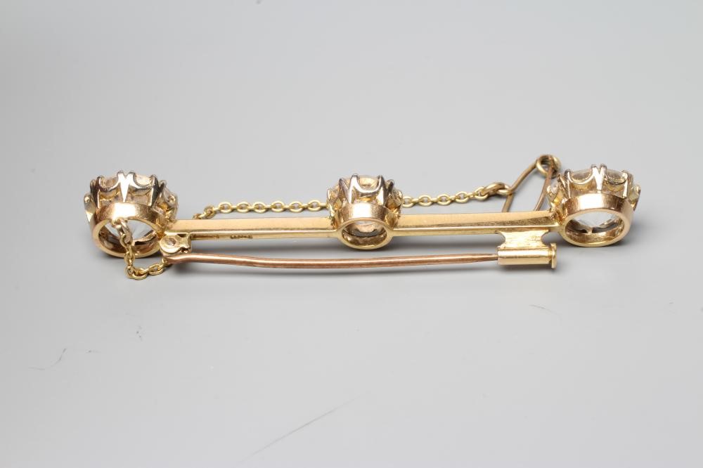 A BAR BROOCH, the knife edge bar claw set with three large facet cut stones, possibly white Image
