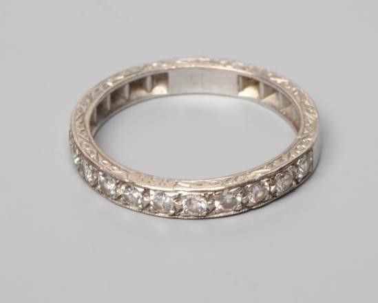 AN ELEVEN STONE DIAMOND HALF HOOP RING, the old cut stones point set to a white shank with scroll Image