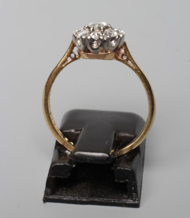 A NINE STONE DIAMOND CLUSTER RING, the round brilliant cut stones point set to plain shoulders and Image