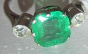 AN EMERALD AND DIAMOND THREE STONE RING Image