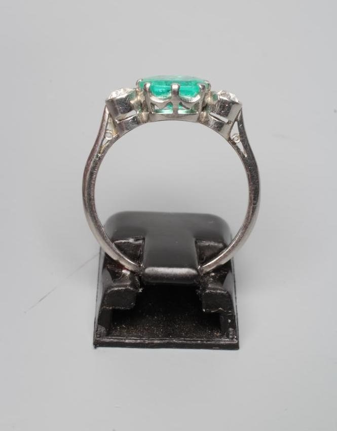AN EMERALD AND DIAMOND THREE STONE RING Image