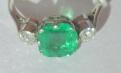 AN EMERALD AND DIAMOND THREE STONE RING Image