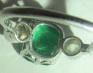 AN EMERALD AND DIAMOND THREE STONE RING Image