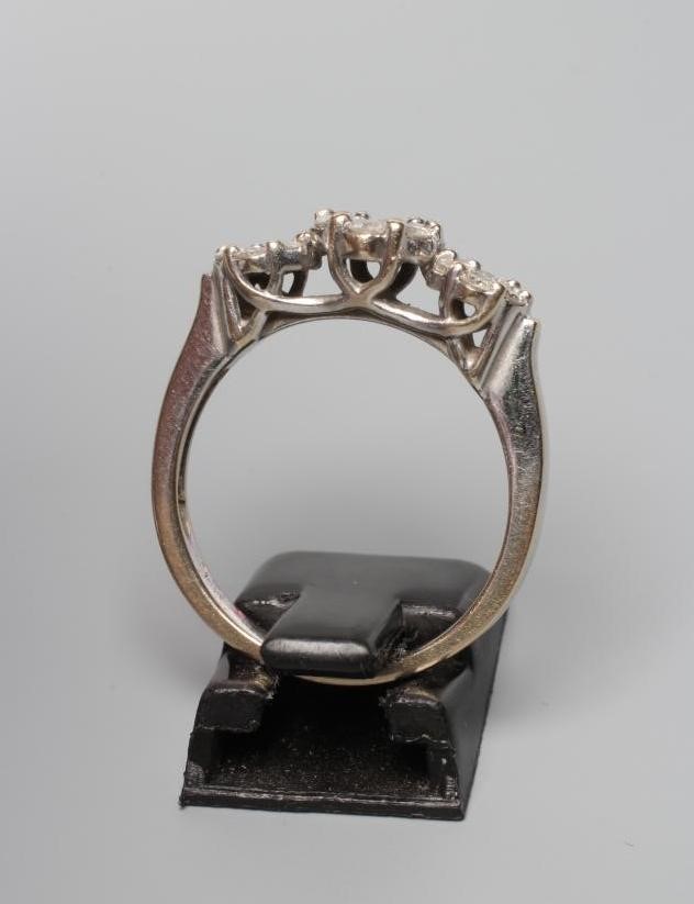 A DIAMOND TRIPLE CLUSTER RING, the graduated seven stone clusters claw set to a plain shank stamped Image