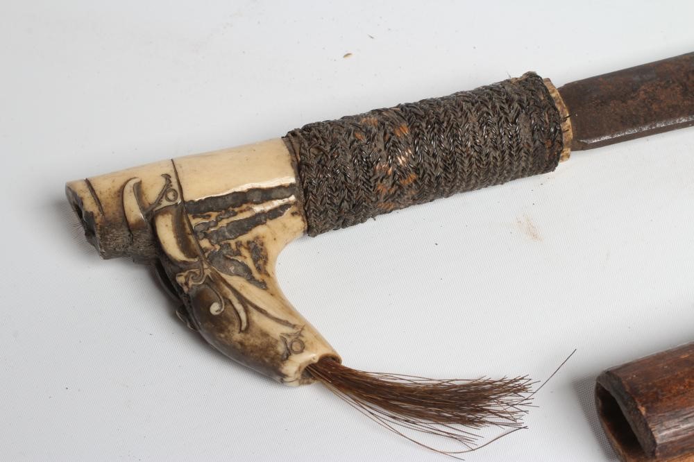A DAYAK HEAD-HUNTER'S SWORD, the 21" blade shaped and decorated at the tip, carved bone handle, Image