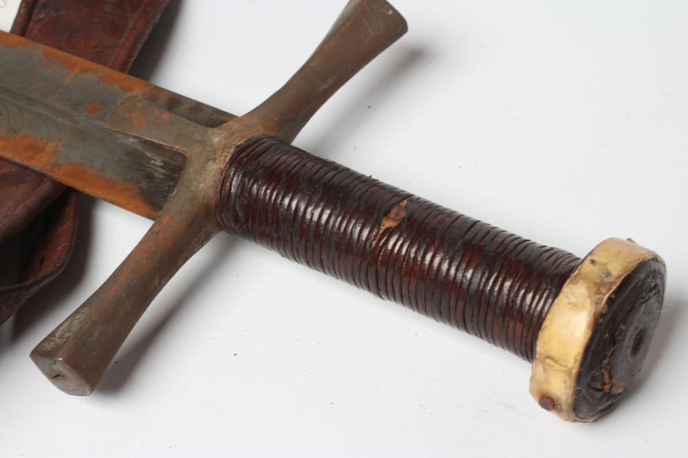 A SUDANESE KASKARA SWORD, the 34 1/2" blade etched with script and repeating designs, cruciform Image