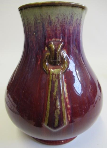 A CHINESE SANG DE BOEUF GLAZED VASE of baluster form with two fixed ring and tassel 'handles' Image