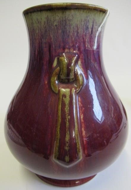 A CHINESE SANG DE BOEUF GLAZED VASE of baluster form with two fixed ring and tassel 'handles' Image