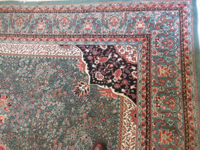 A TURKISH CARPET, modern, the pale green floral ground with central gul in pink, ivory and black Image