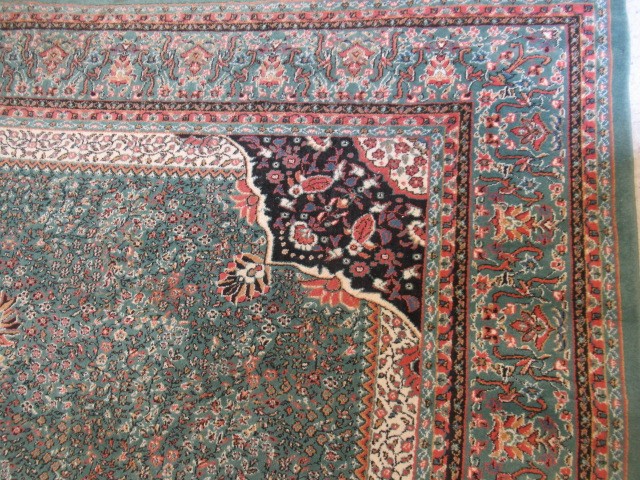 A TURKISH CARPET, modern, the pale green floral ground with central gul in pink, ivory and black Image