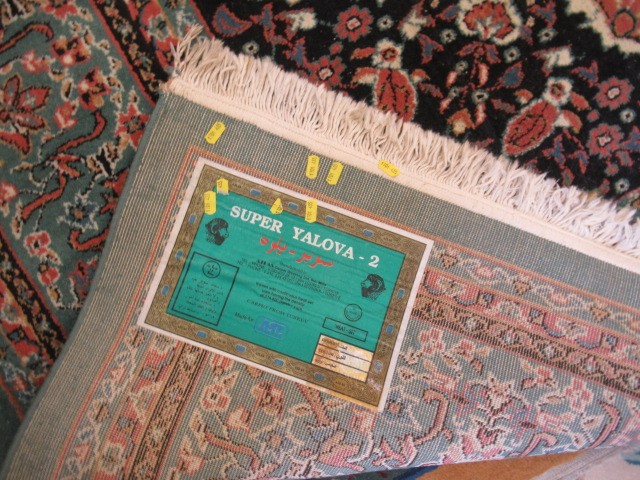 A TURKISH CARPET, modern, the pale green floral ground with central gul in pink, ivory and black Image