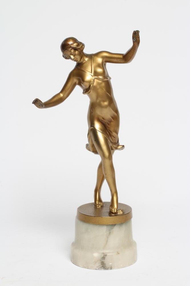 AN ART DECO GILDED SPELTER DANCING FIGURE cast as a scantily draped young lady Image