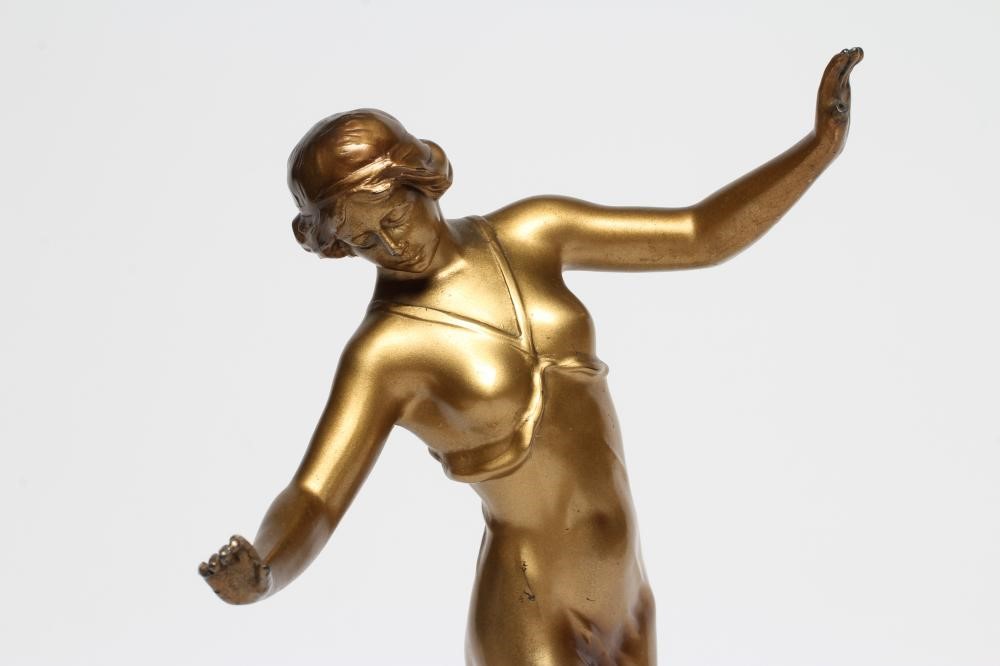 AN ART DECO GILDED SPELTER DANCING FIGURE cast as a scantily draped young lady Image