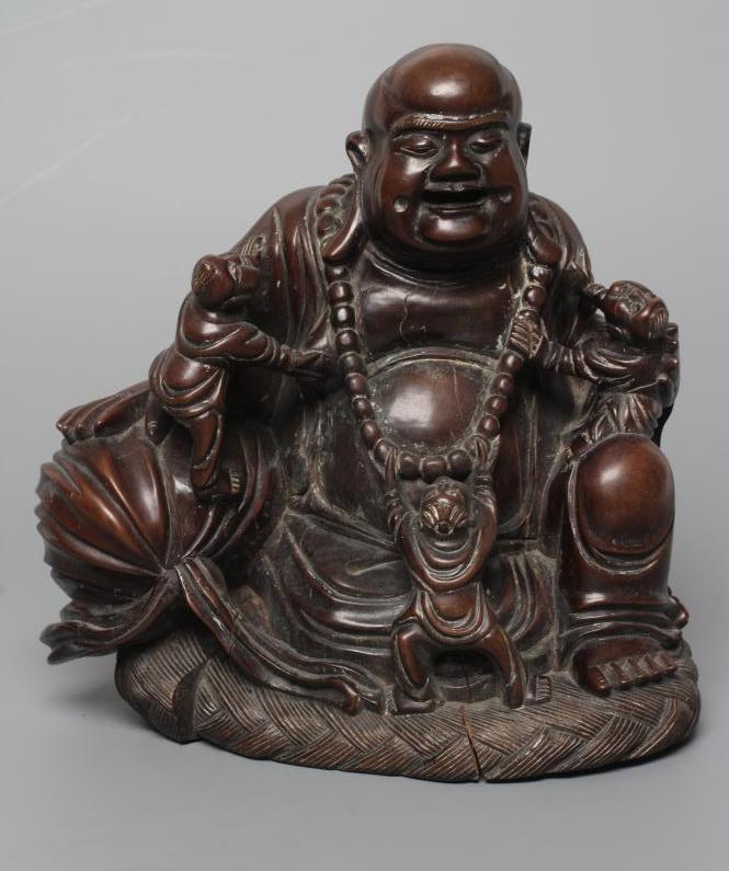 A CHINESE CARVED HARDWOOD BUDDAH, seated wearing a long bead necklace and with three children in Image