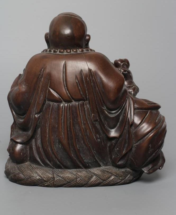 A CHINESE CARVED HARDWOOD BUDDAH, seated wearing a long bead necklace and with three children in Image