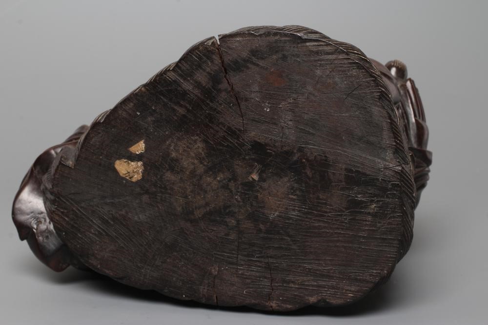 A CHINESE CARVED HARDWOOD BUDDAH, seated wearing a long bead necklace and with three children in Image