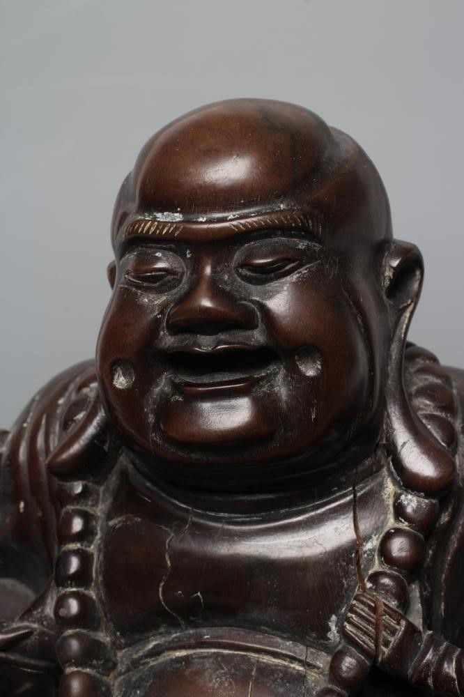 A CHINESE CARVED HARDWOOD BUDDAH, seated wearing a long bead necklace and with three children in Image