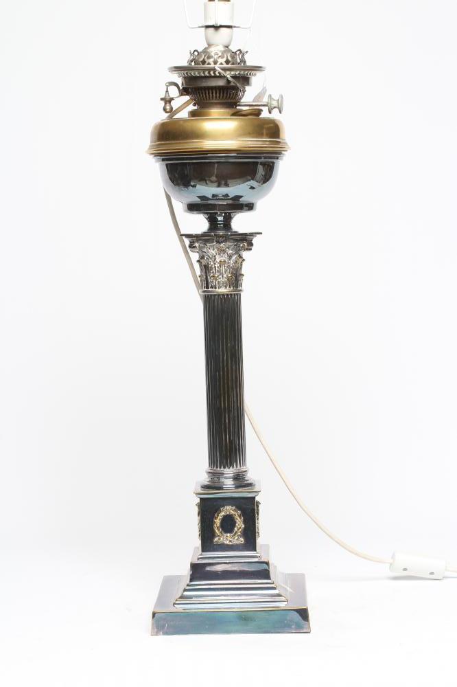 AN EDWARDIAN TABLE OIL LAMP, the reservoir raised on a Corinthian column, on stepped square base, Image