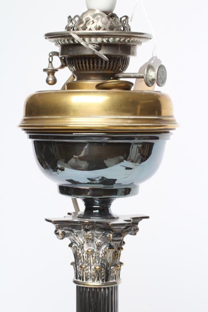 AN EDWARDIAN TABLE OIL LAMP, the reservoir raised on a Corinthian column, on stepped square base, Image