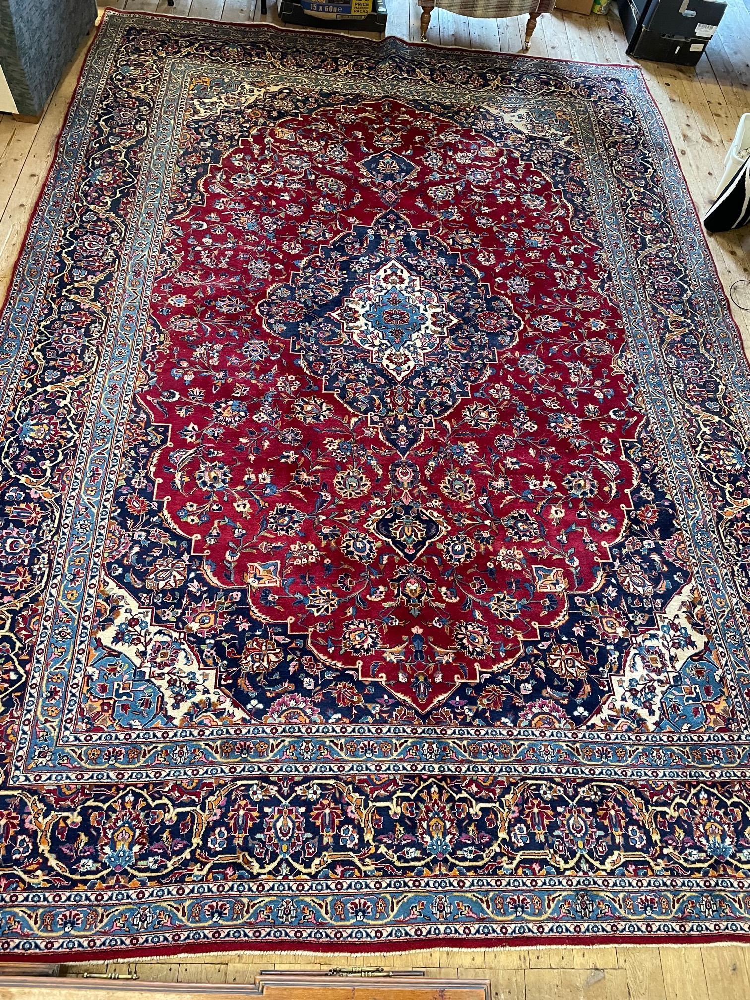 A KASHAN CARPET, the crimson floral field centred by an ivory and blue gul, similar spandrels within Image
