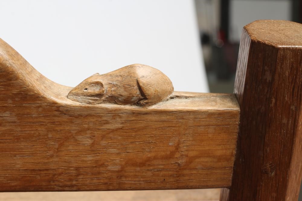 A ROBERT THOMPSON OAK MAGAZINE RACK with panelled sides and loop handle, on octagonal supports and Image