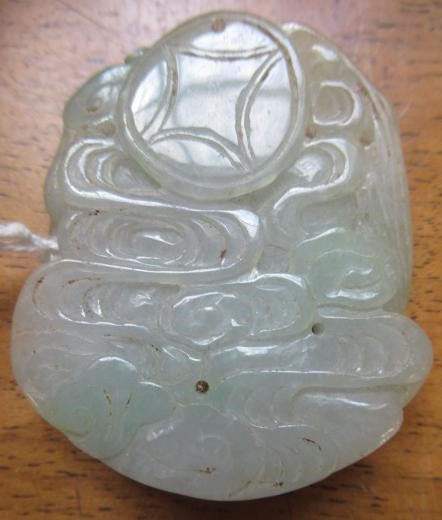 A CHINESE TWO TONE JADE PANEL carved and pierced with a man holding a cup Image