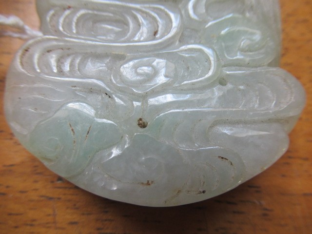 A CHINESE TWO TONE JADE PANEL carved and pierced with a man holding a cup Image